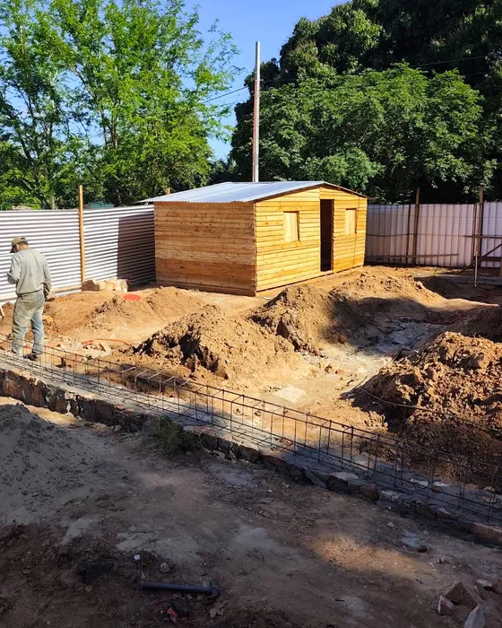 La casa de madera ya armada en un terreno, con un obrero trabajando al lado