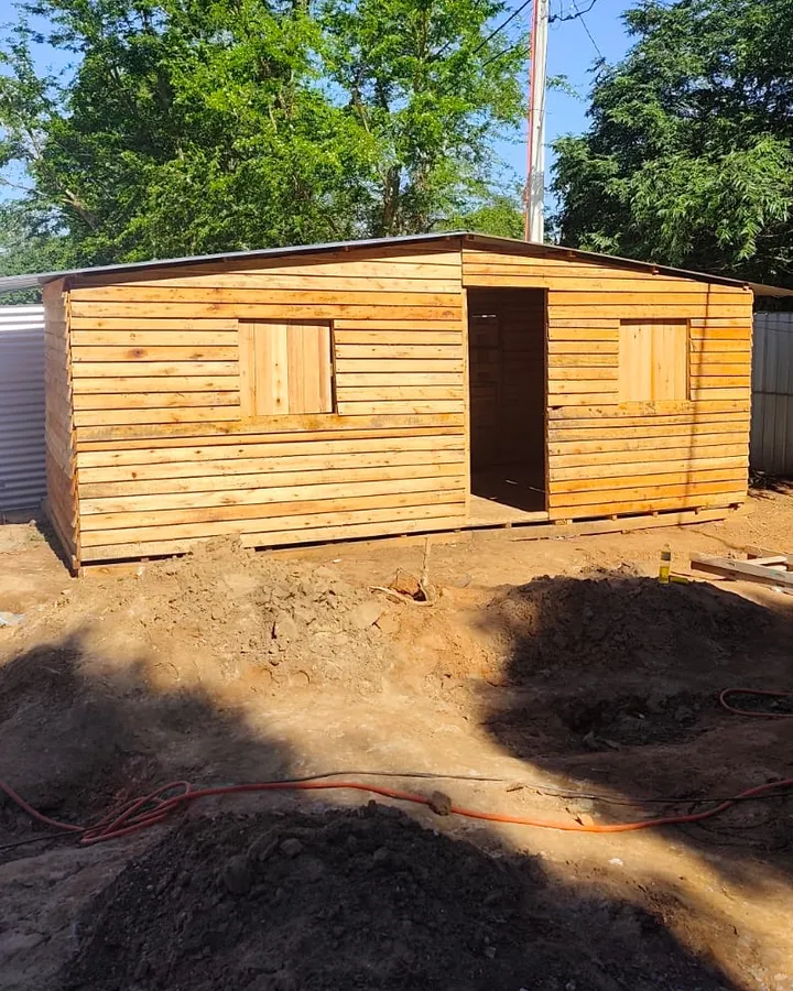 La casa de madera de Forest+ armada en un terreno, con dos ventanas, puerta y techo de chapa